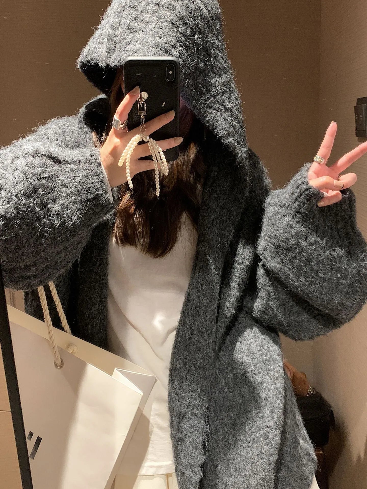 Women's loose hooded cardigan in thick acrylic blend, shown in dark grey, brown, and milky white.