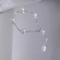 Gold starry pearl choker necklace on a white surface showing imitation pearl chain