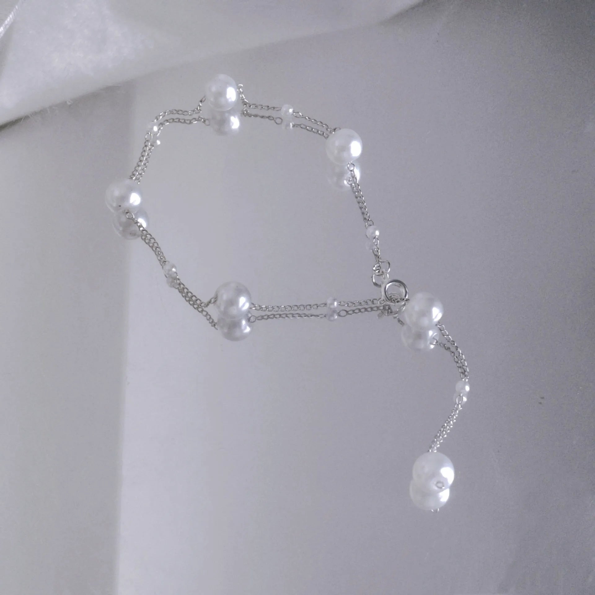 Gold starry pearl choker necklace on a white surface showing imitation pearl chain