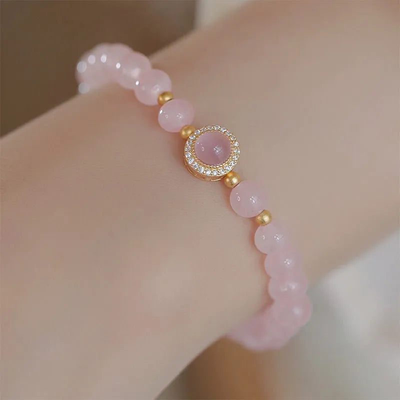 Aquamarine crystal bracelet with mixed materials including pink beads, white pearls, and peach blossom elements