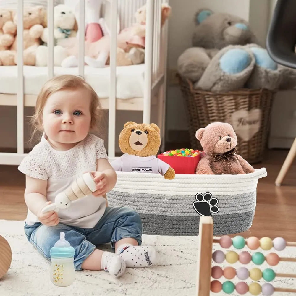 Light beige handmade woven cotton rope storage basket with handle on a wooden surface.