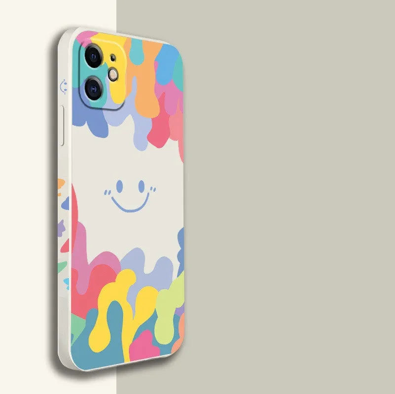 White and black silicone iPhone cases featuring a large rainbow smiley face design, shown with attached lanyards.