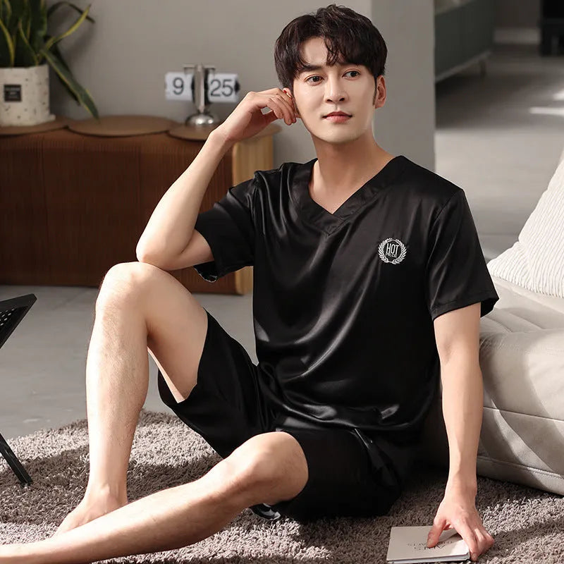 Man wearing a light grey ice silk short-sleeve pajama shirt and matching loose shorts.