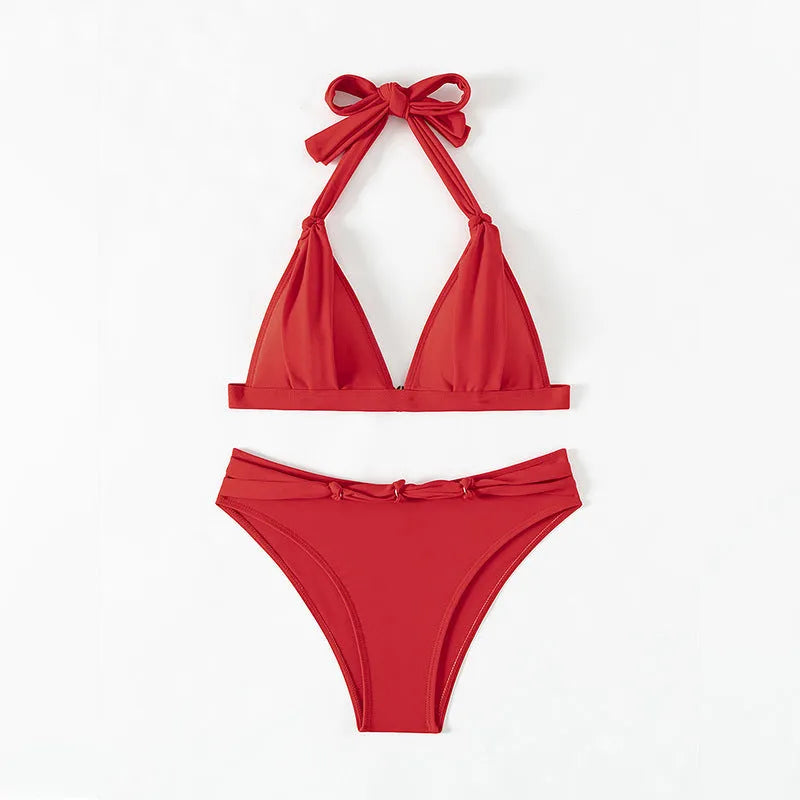 Red women's lace-up halterneck bikini set with matching shorts on a plain background.