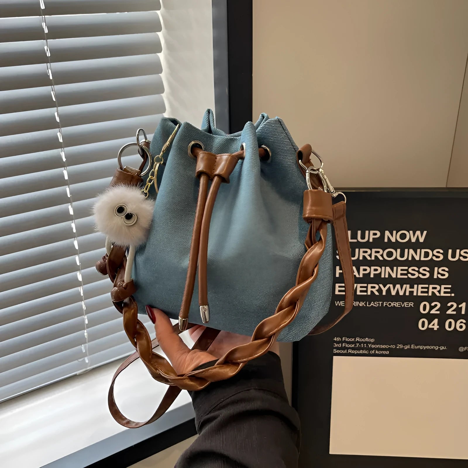 Blue synthetic leather cross body bucket bag with optional hanging ornaments