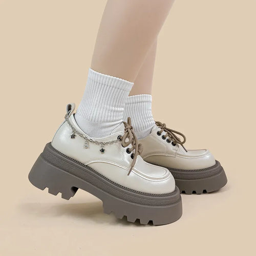White platform Mary Jane shoes with chunky heel and metal decorations on display