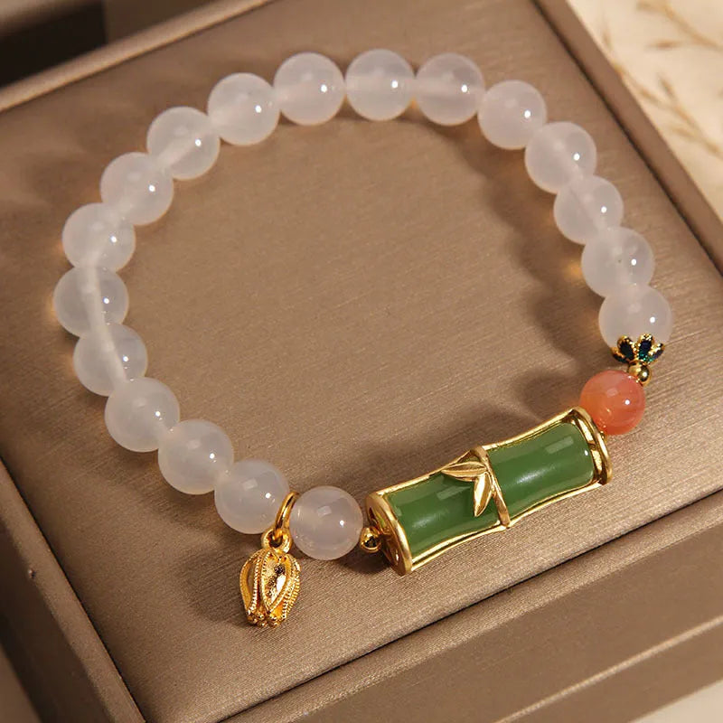 Women's white agate jade bracelet with bamboo joint beads on a wrist.