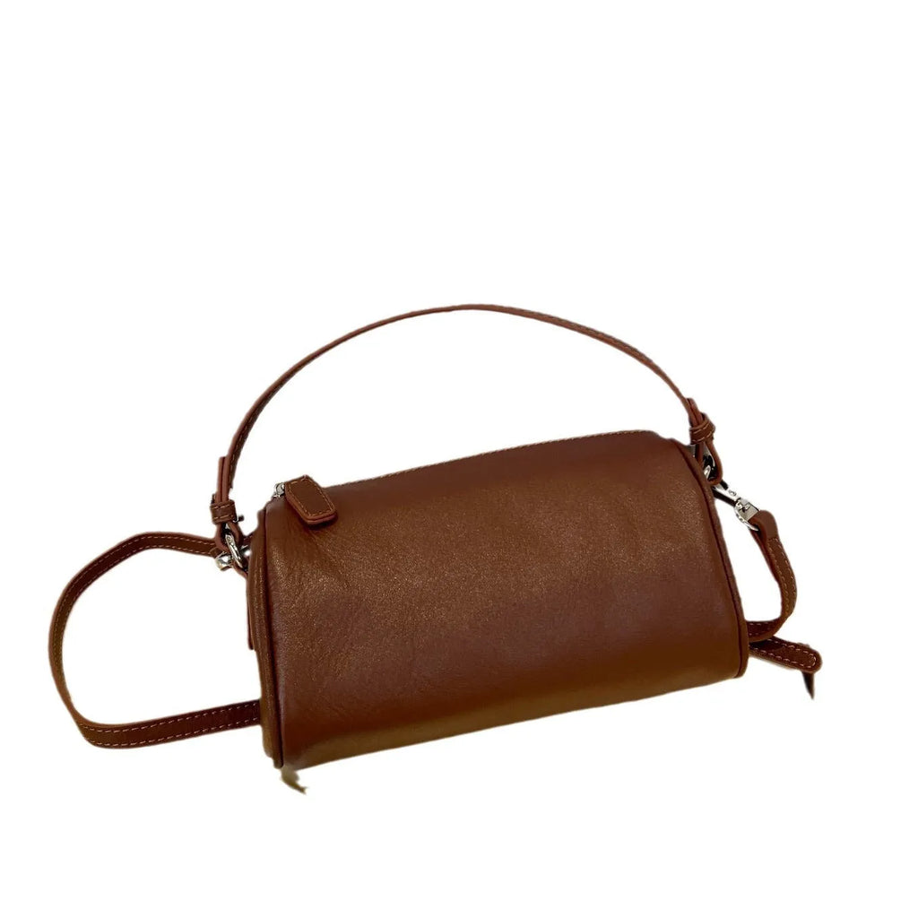A soft genuine leather cylindrical crossbody bag for mobile phones in street style.