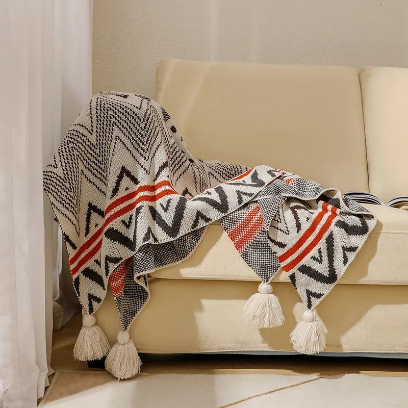 Acrylic sofa blanket with tassels in geometric pattern colour option on a sofa