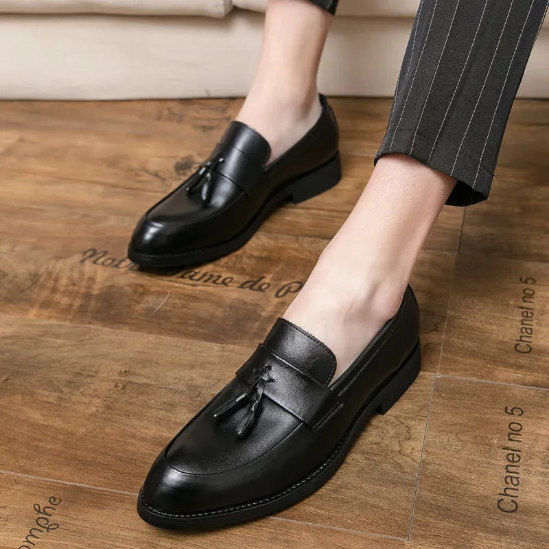 Men's black slip-on business casual shoes with a tassel detail and rubber sole.