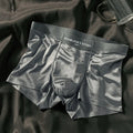 Men's solid colour ice silk nylon underwear in mid waist design on a neutral background.