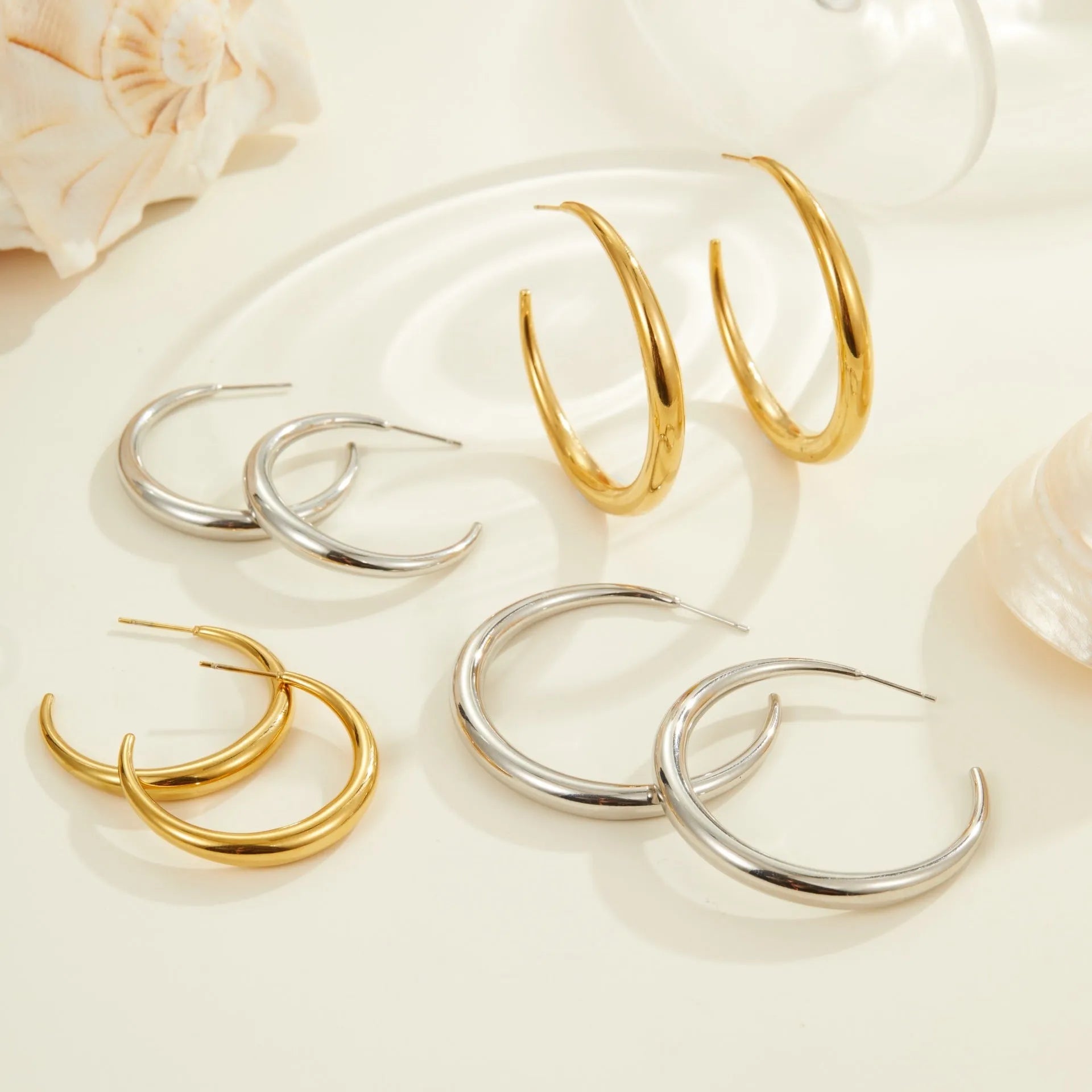 Simple round stainless steel hoop earrings for women in gold and steel colours, available in two sizes.