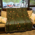 Chinese retro green plum blossom woven polyester sofa cover 130x160cm with tassels on a sofa
