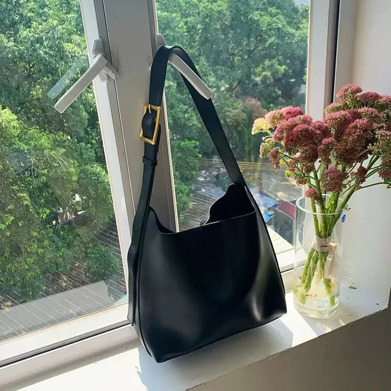 Women's soft PU leather shoulder bag with swing threads in black and brown colours showing ribbon and pocket detailing