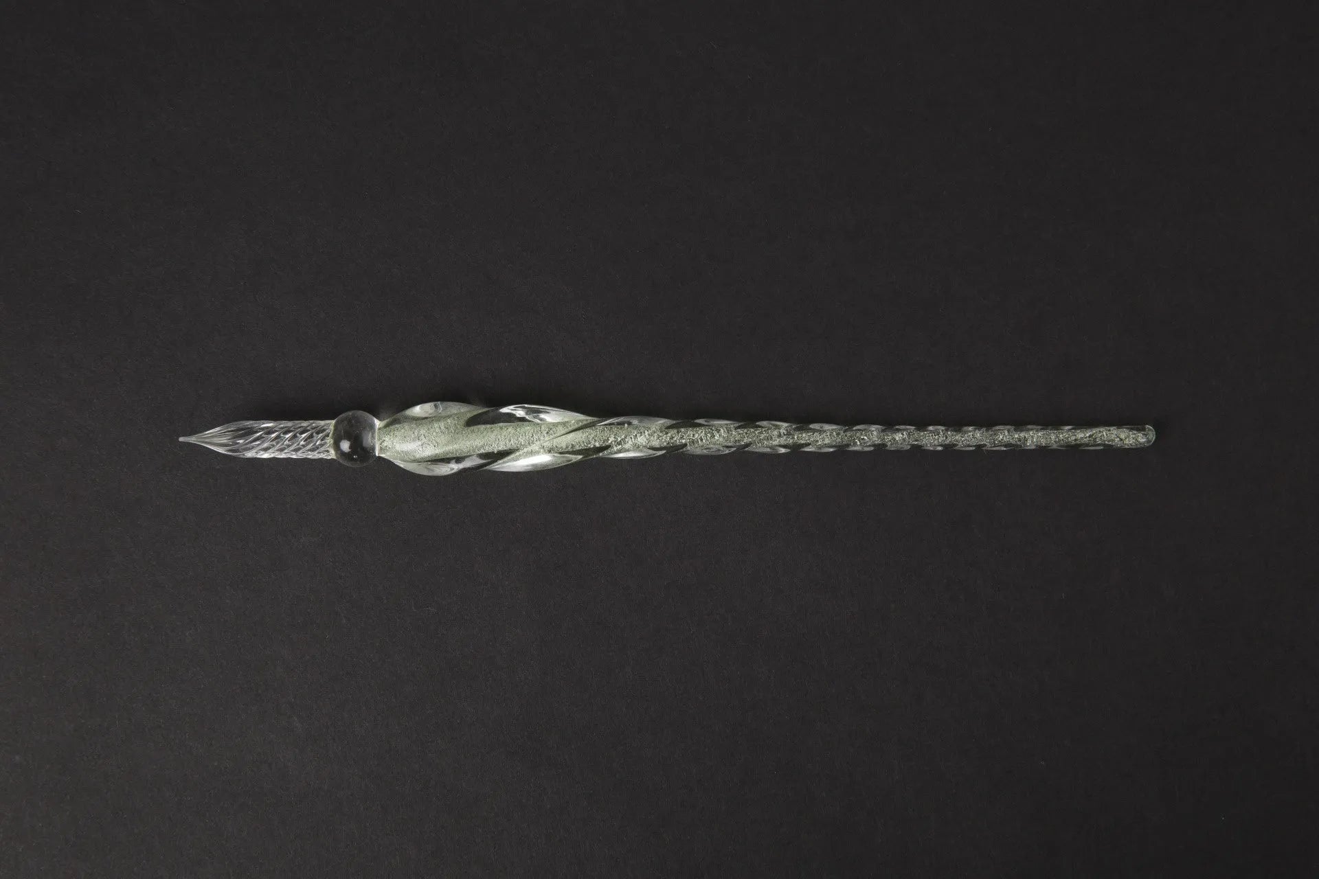 Hand-blown glass crystal pen with coloured ink in a transparent barrel on a gift box.