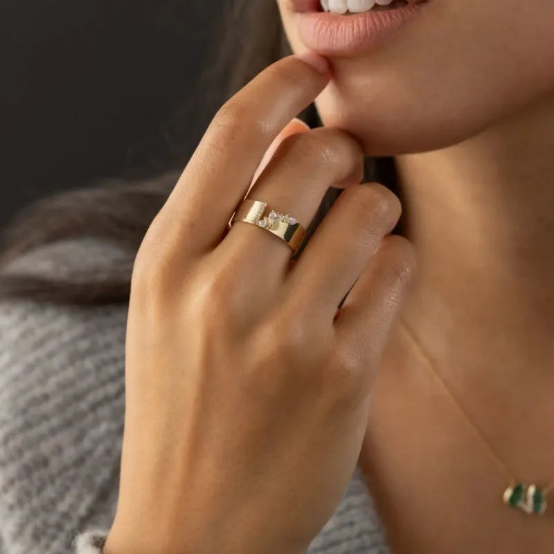 Gold-plated copper ring with shining zircon stones on a white background