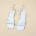 Women's flat sandals with ankle bandage strap in white, featuring a square toe and front lace-up.
