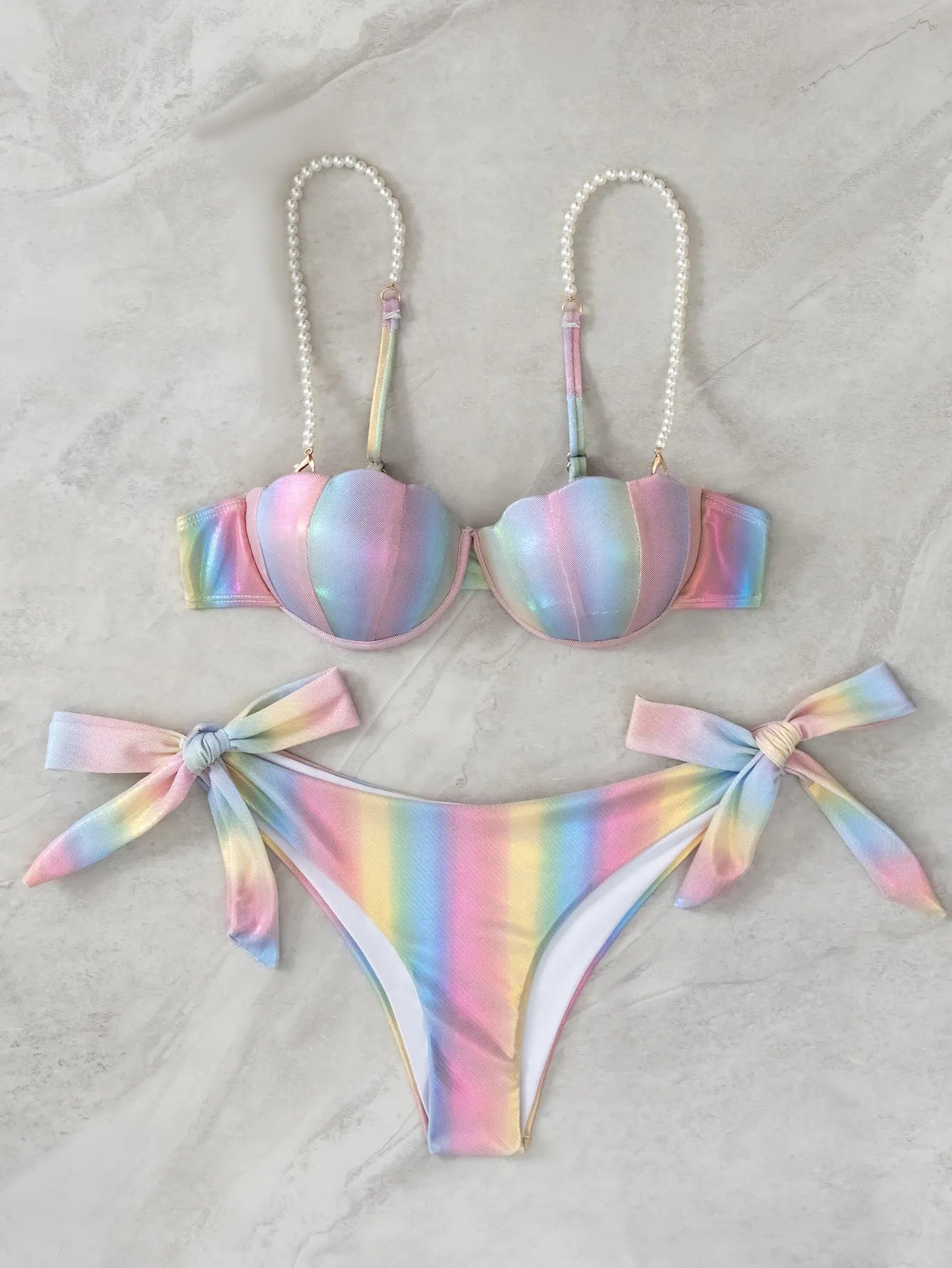 Women's shell rainbow coloured split bikini swimsuit with tied design on a mannequin.