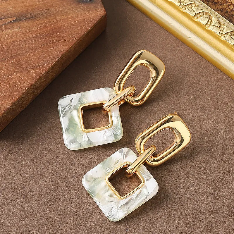 Pair of hollow geometric square earrings with chamfered pattern in silver or black electroplated finish.