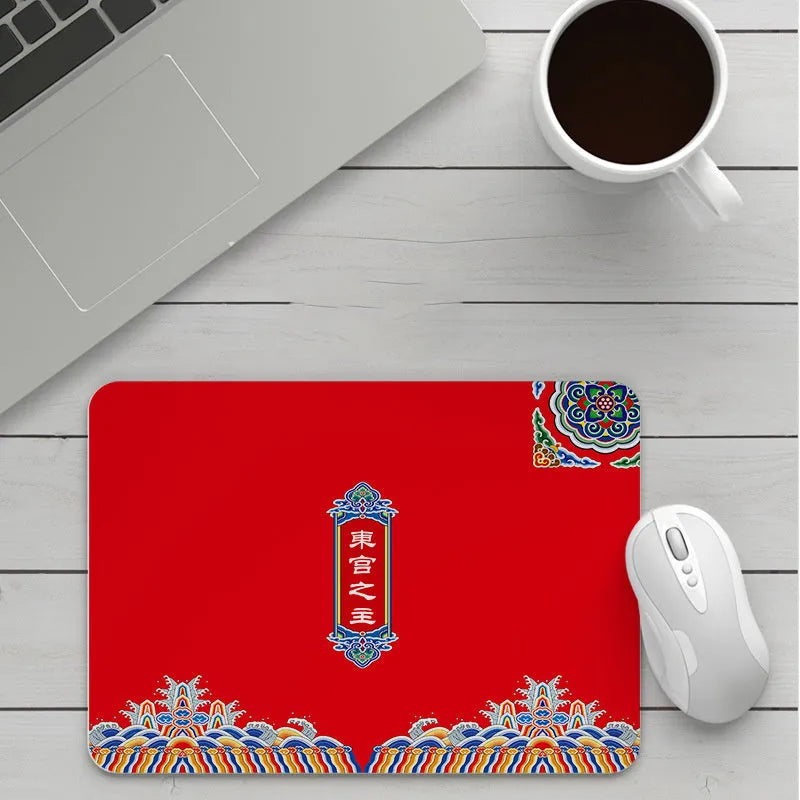 Custom cartoon design on a small black thickened mouse pad with stitching, shown on a desk.
