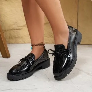 Women's black loafers with a decorative bow on the front, made from artificial PU.