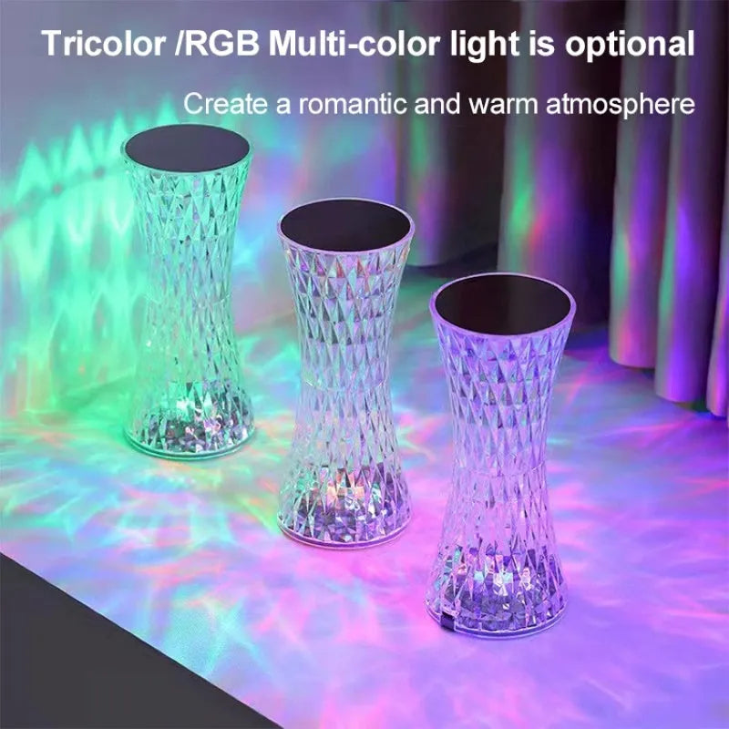 Clear plastic vase-shaped crystal bedside lamp with LED lights on a wooden table.