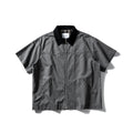 Washed khaki loose-fit cotton overalls shirt with short sleeves on a hanger.