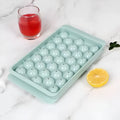 Blue silicone ice cube tray with lid showing 33 round compartments