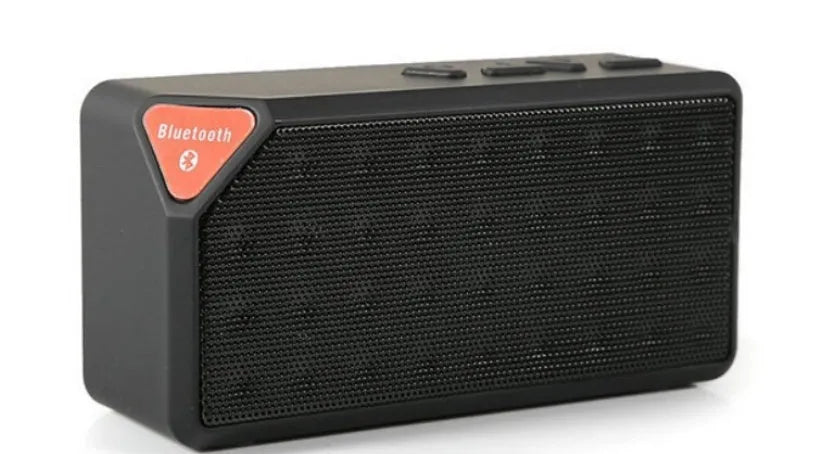 Cannon X3 small cube-shaped portable Bluetooth speaker in multiple colours on a table