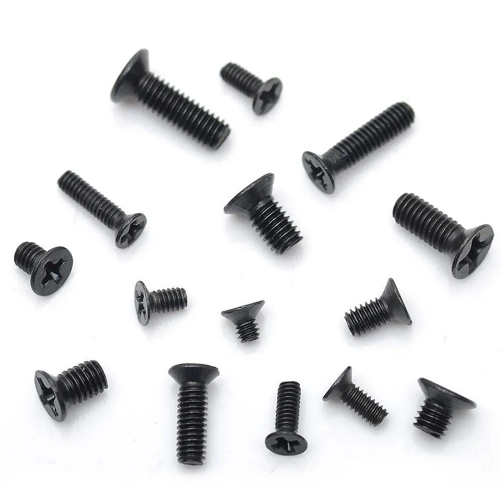Bulk set of small black countersunk head machine screws for laptop repair on a white background.