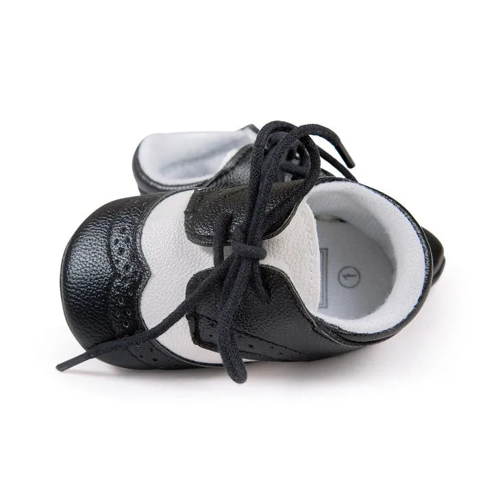 Vintage style soft-soled baby shoes for boys in synthetic leather, available in black, grey, light brown, and white.