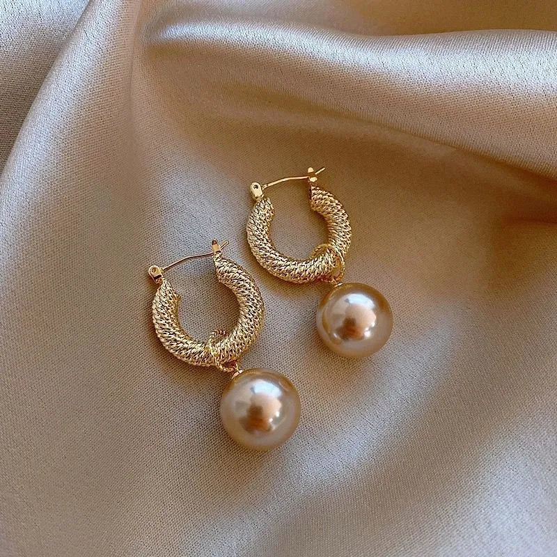 A pair of women's geometric copper earrings with a rose design and small zircon stone accents.
