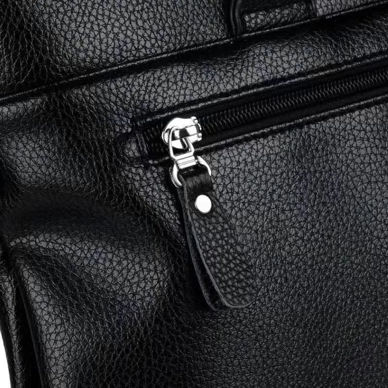 Men's black and brown PU leather business messenger bag with splicing design on a table.