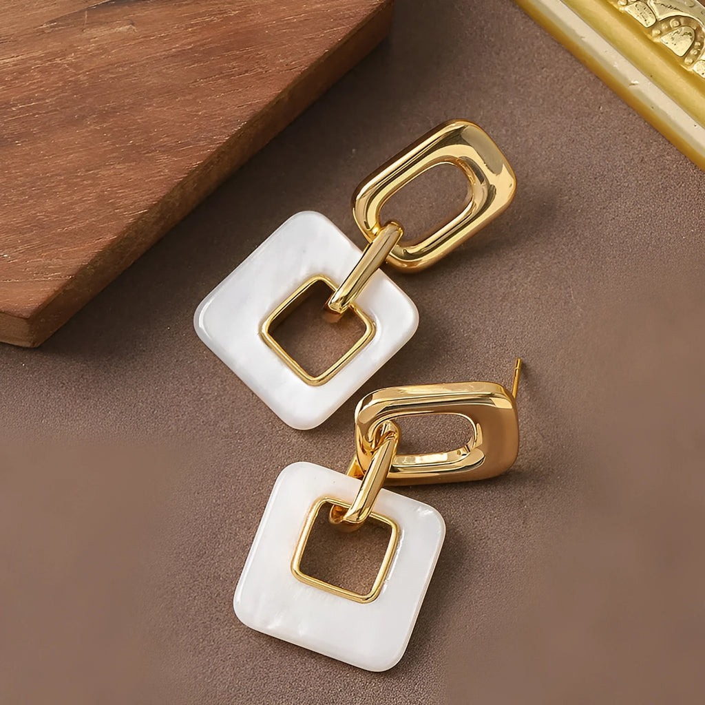 Pair of hollow geometric square earrings with chamfered pattern in silver or black electroplated finish.