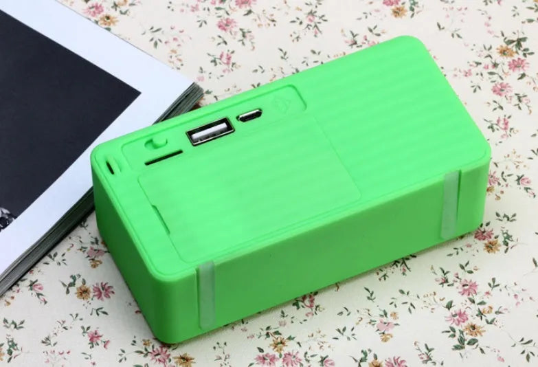 Cannon X3 small cube-shaped portable Bluetooth speaker in multiple colours on a table