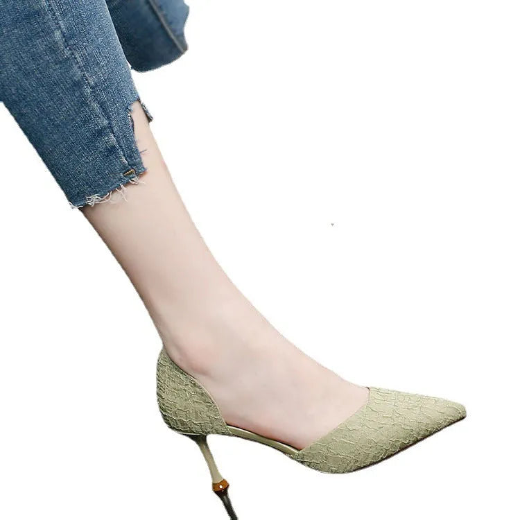 Women's black pointed leather high heel shoes with a stiletto heel on a plain background.