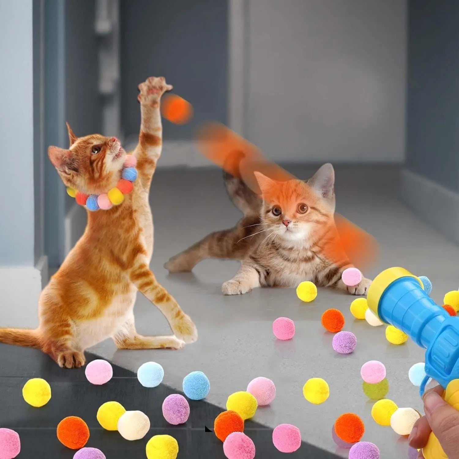 Cat toy ball launcher gun in hand with 20 soft plush pom pom balls for interactive fetch play