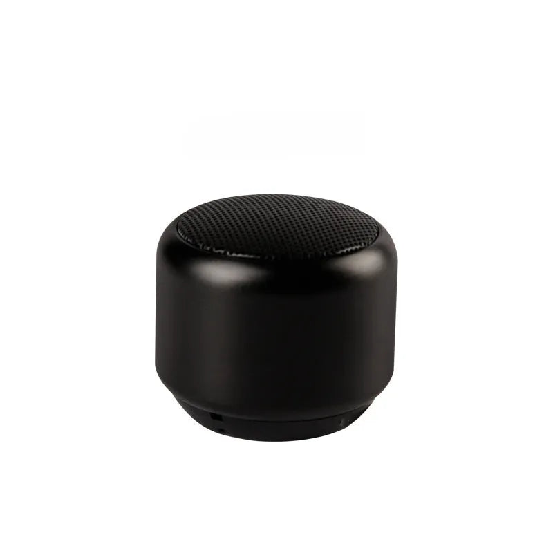 A small portable Bluetooth speaker shown in one of four colour options: black, blue, gold, or pink.