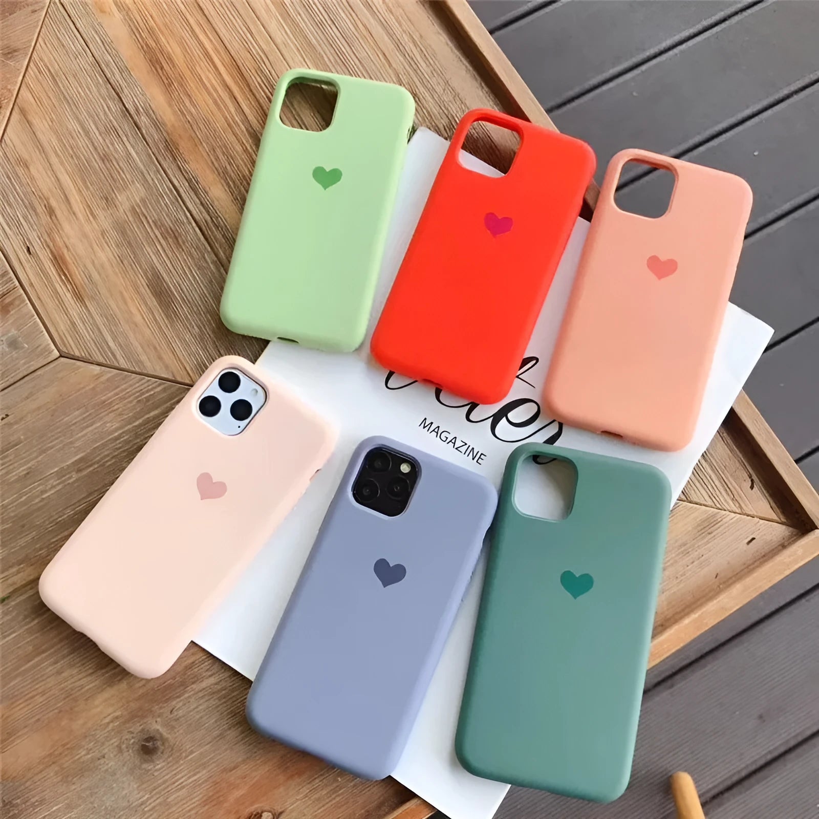 Solid colour silicone phone case for iPhone, shown in dark green, on a wooden surface.