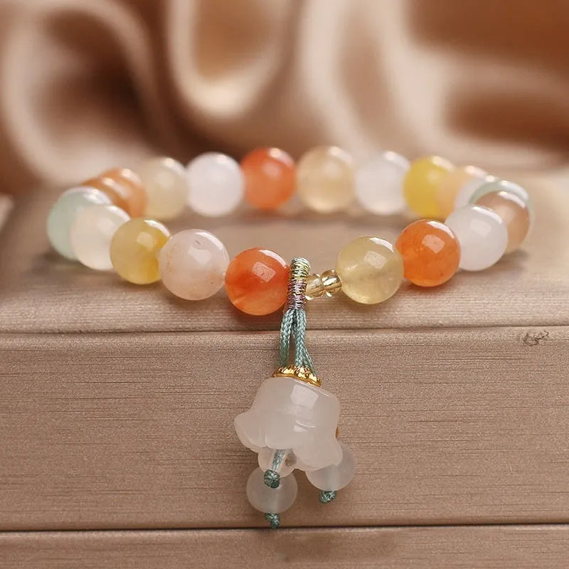 Natural Jinsi Jade round bead beaded bracelet with lily pendant on neutral background