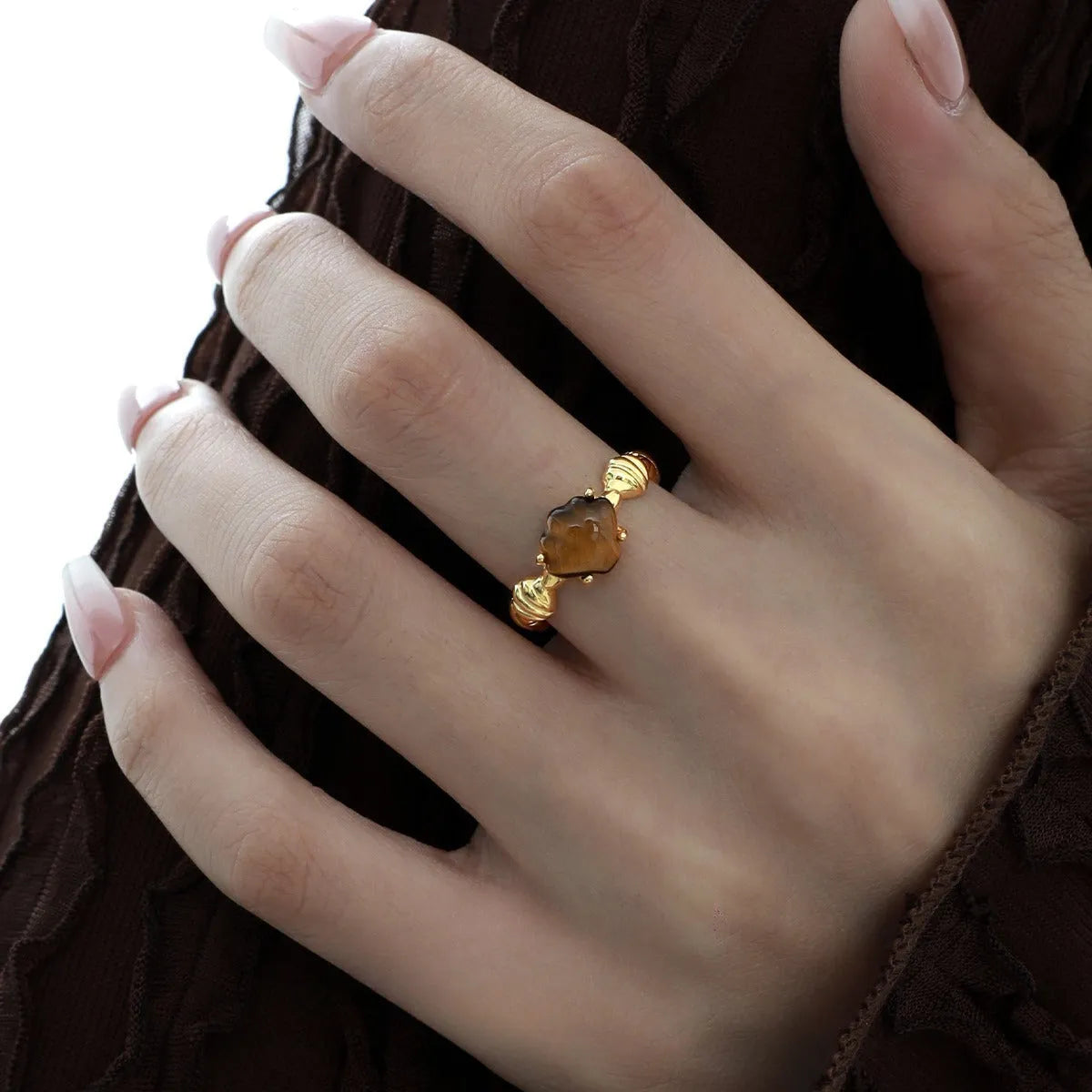 Silver adjustable ring with a tiger eye shell design and gold electroplated finish.