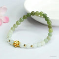 Hand-woven clear water gradient Hetian jade bracelet with flower-shaped beads on a white background.