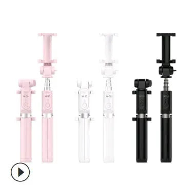Black Bluetooth selfie stick tripod with extended rod, phone clamp, and deployed legs next to a smartphone