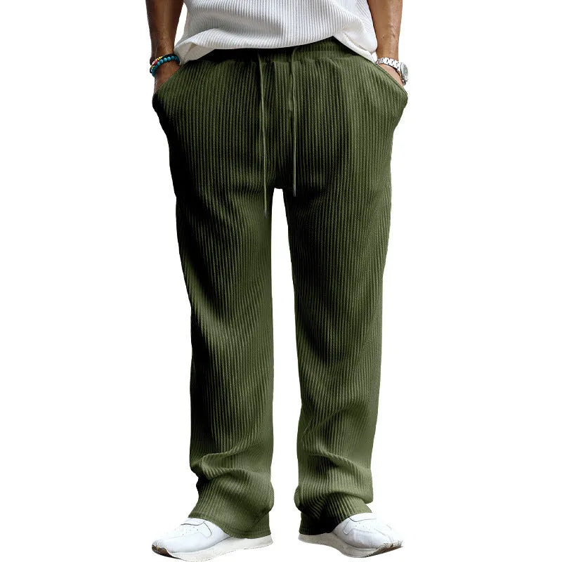 Man wearing casual loose-fit high-waist straight-leg striped trousers in a solid colour.