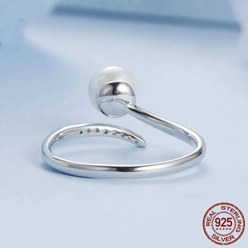 Adjustable sterling silver ring with natural shell pearls showing open loop design