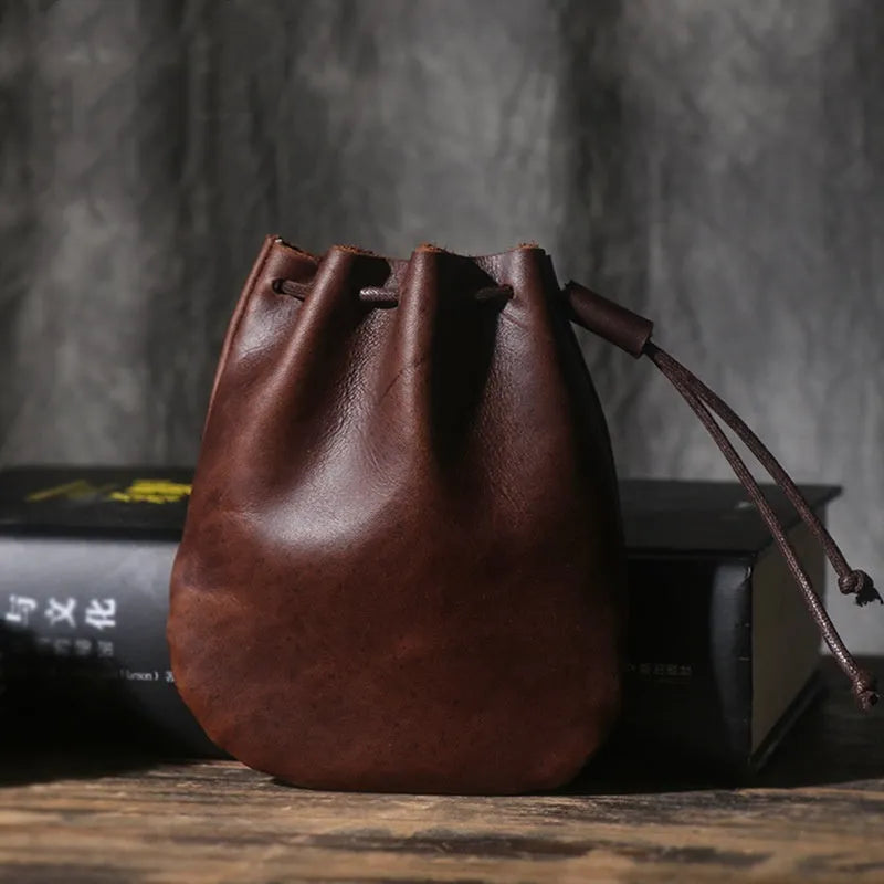 Vintage cowhide drawstring bundle wallet in chocolate brown showing sewing thread detail.