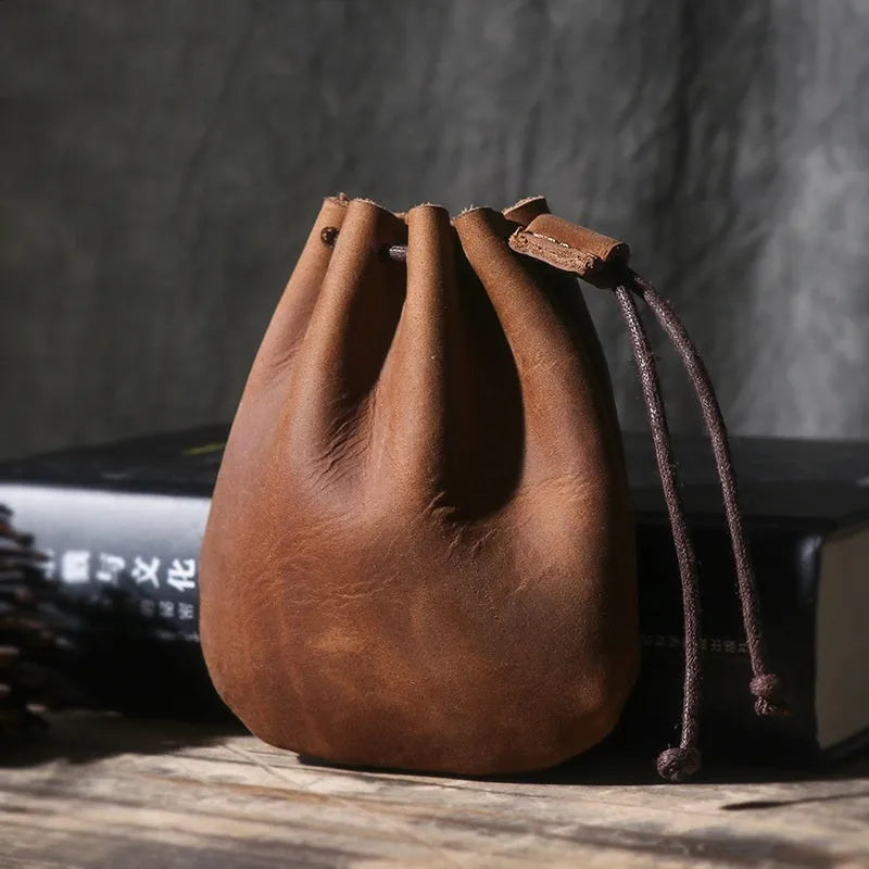 Vintage cowhide drawstring bundle wallet in chocolate brown showing sewing thread detail.