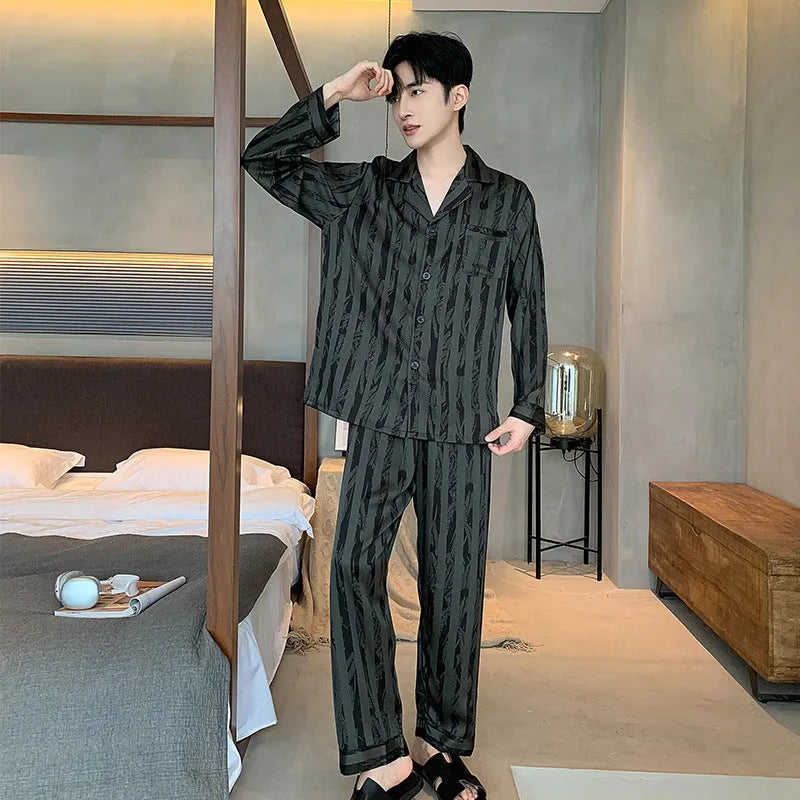Men's black striped Ice Silk long sleeve V-neck pajama top and thin trousers set laid flat.