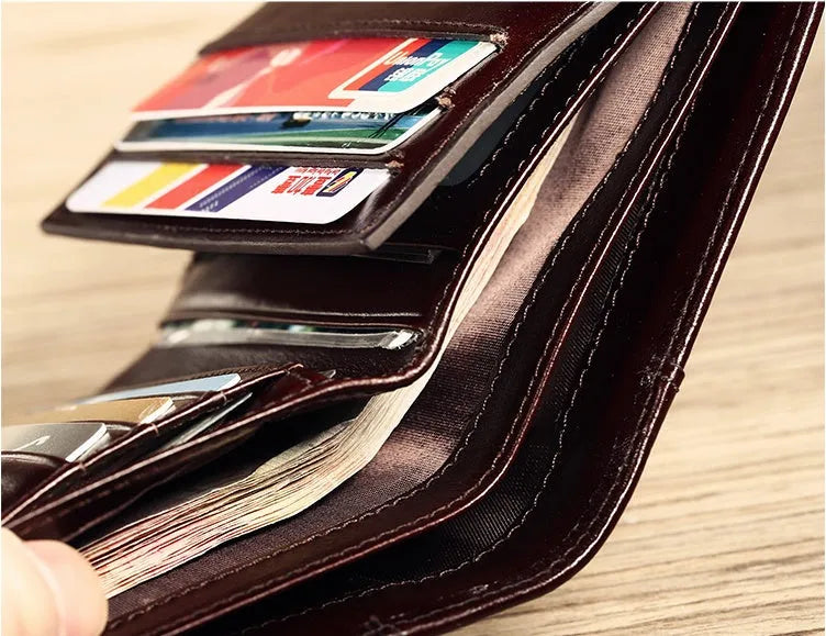 Men's black leather wallet open to show internal card slots, coin pocket, photo holder, and document section.