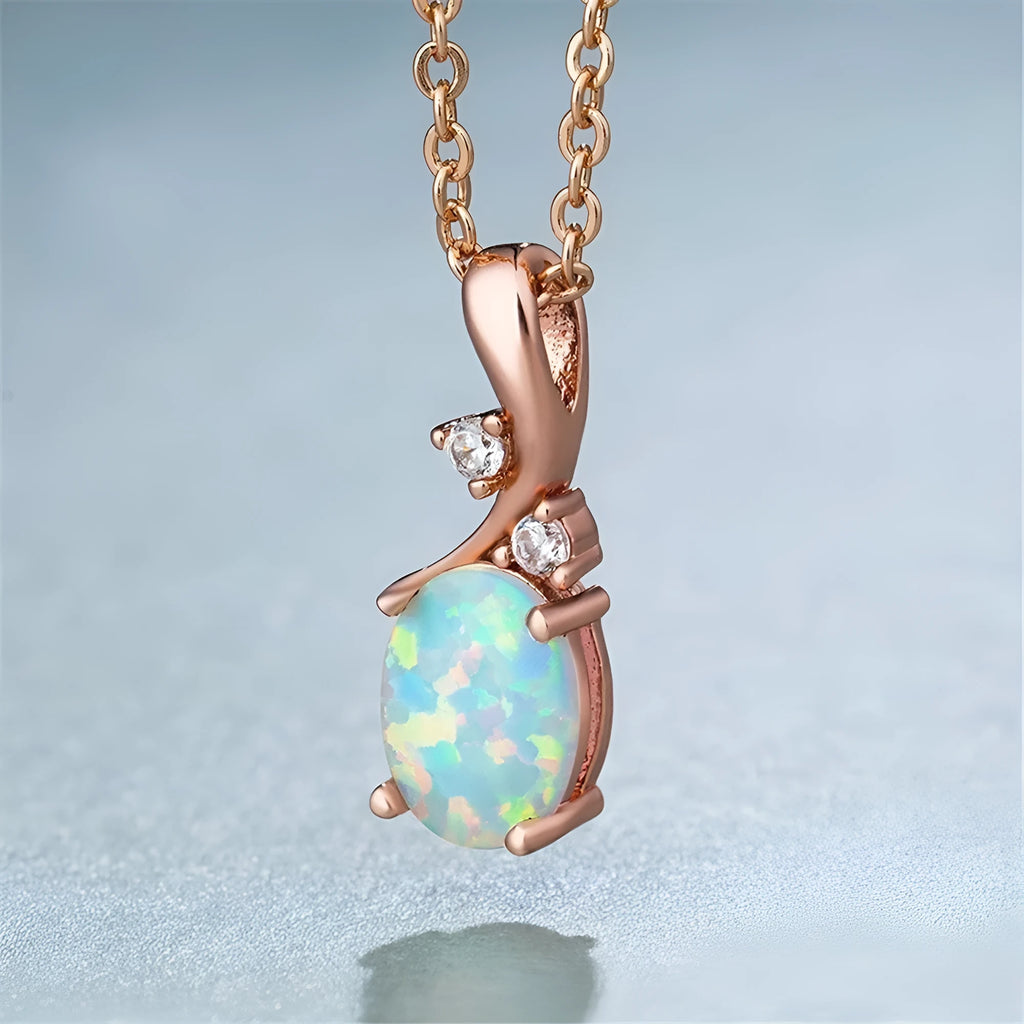 Close-up of a water drop shaped opal pendant on an adjustable O-link chain, shown in a rose gold finish.